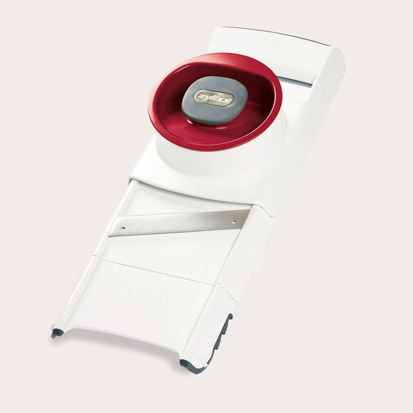 The Zyliss 4-in-1 Slicer & Grater in white and red, with a stainless steel blade and hand guard, sits on a light background—ideal for fast slicing or grating in any kitchen. 