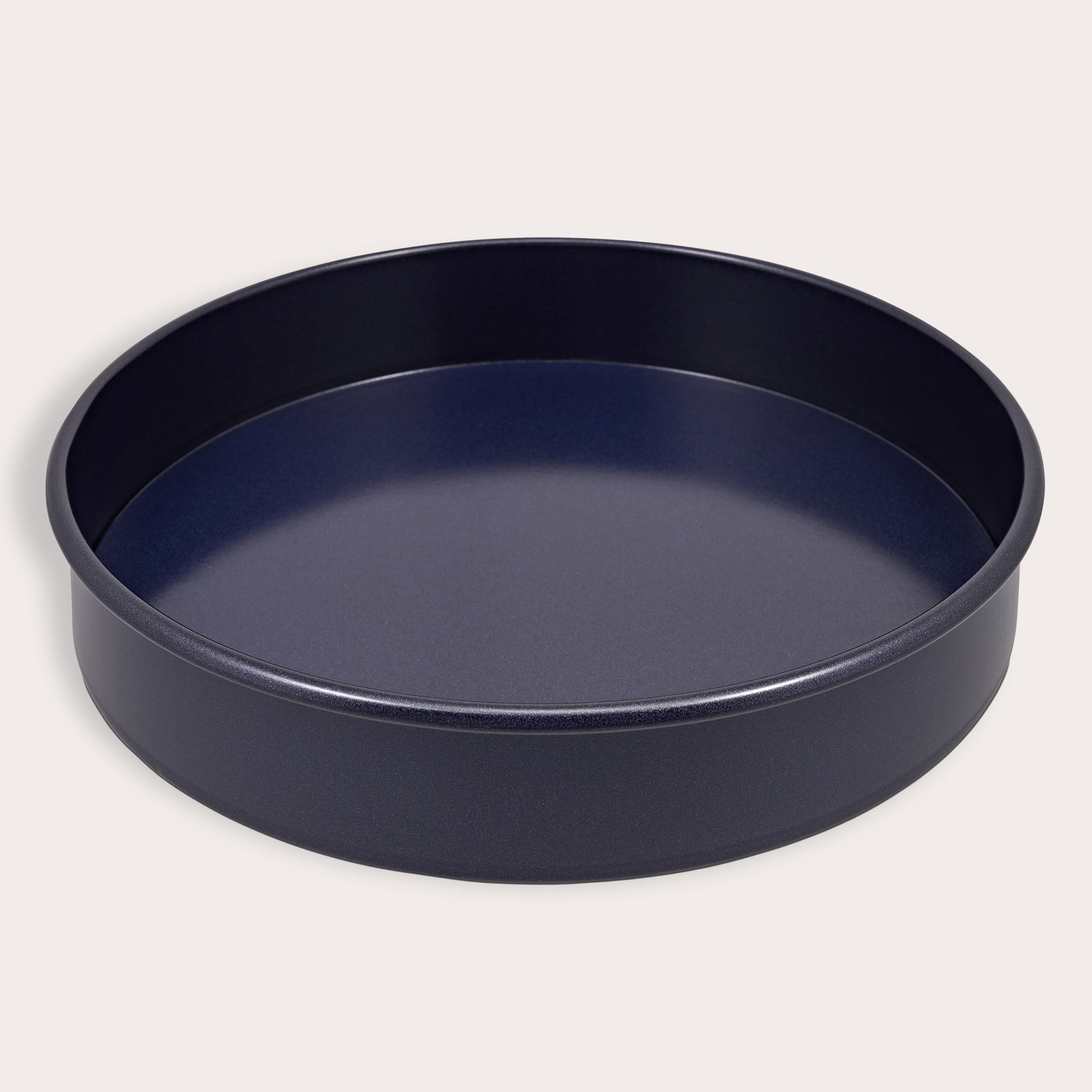 A round, deep, non-stick baking pan with smooth, dark sides and a flat bottom, shown on a plain light background.