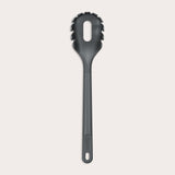 The Zyliss Spaghetti Server is a black, heat-resistant utensil with a long handle and slotted, rounded head featuring prongs for ideal portion control, shown isolated on a light background. 