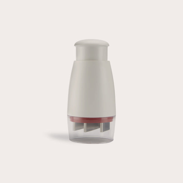 The Zyliss Zick-Zick Classic Food Chopper has a white and gray handheld design, rounded top, transparent base with metal blades, and is ideal for efficient kitchen storage. Shown against a plain light background. 