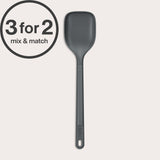 A dark gray, heat-resistant Zyliss Spoon with a hole in the handle is shown vertically against an off-white background. A 3 for 2 mix & match circular label appears in the top left corner.#Large