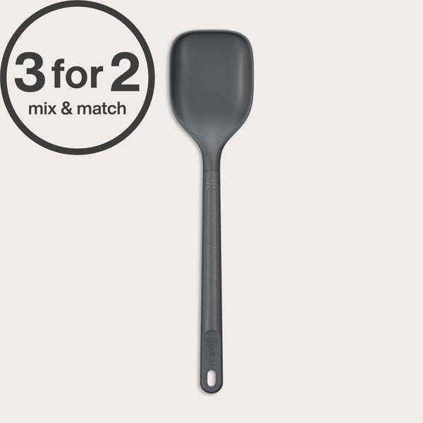 A dark gray, heat-resistant Zyliss Spoon with a hole in the handle is shown vertically against an off-white background. A 3 for 2 mix & match circular label appears in the top left corner.#Large